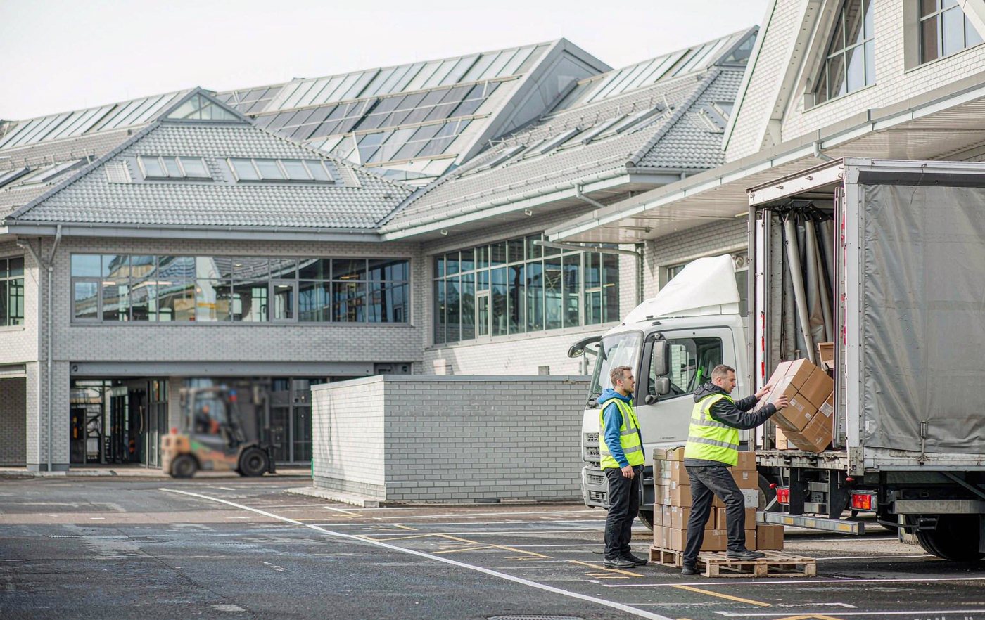 Workers loading pallets onto a delivery truck at a trade distribution centre